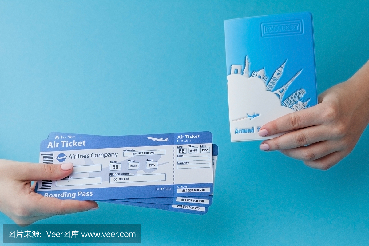 护照和机票拿在女人手里,背景是蓝色的。旅行概念,复制空间